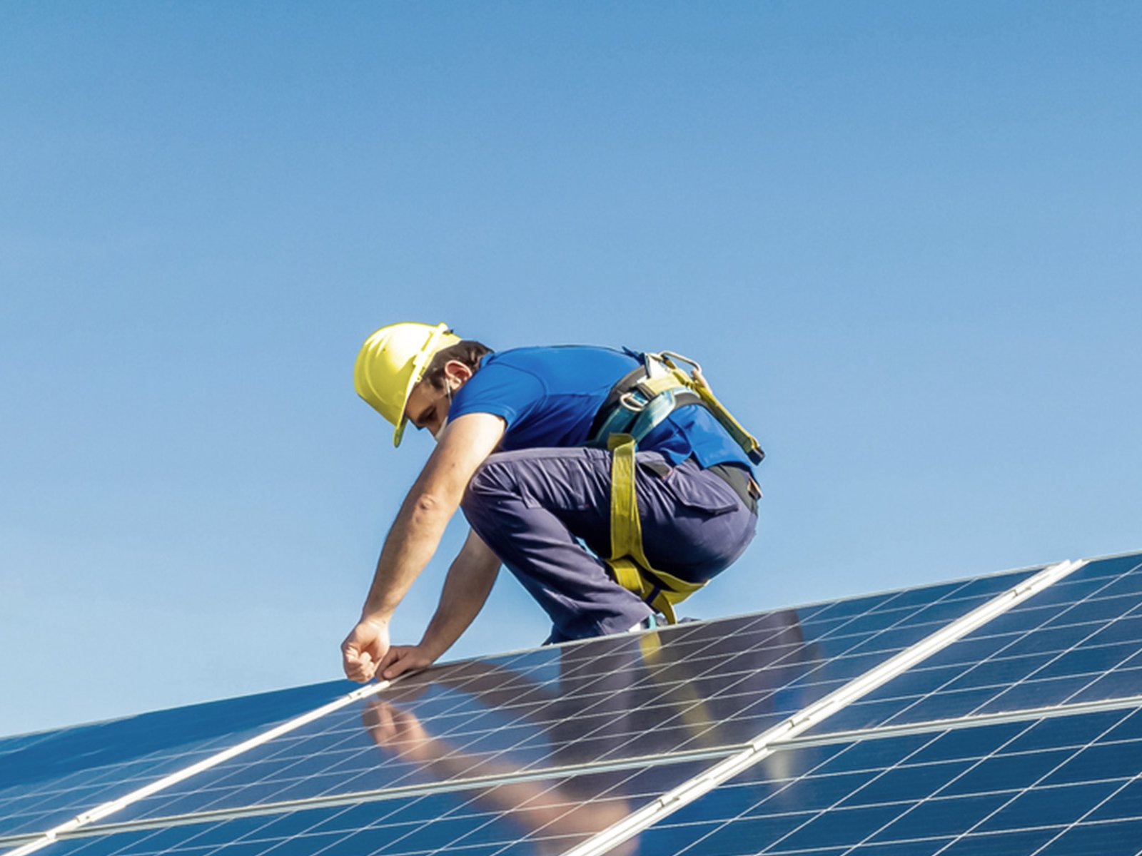 Solar technician working on rooftop panels